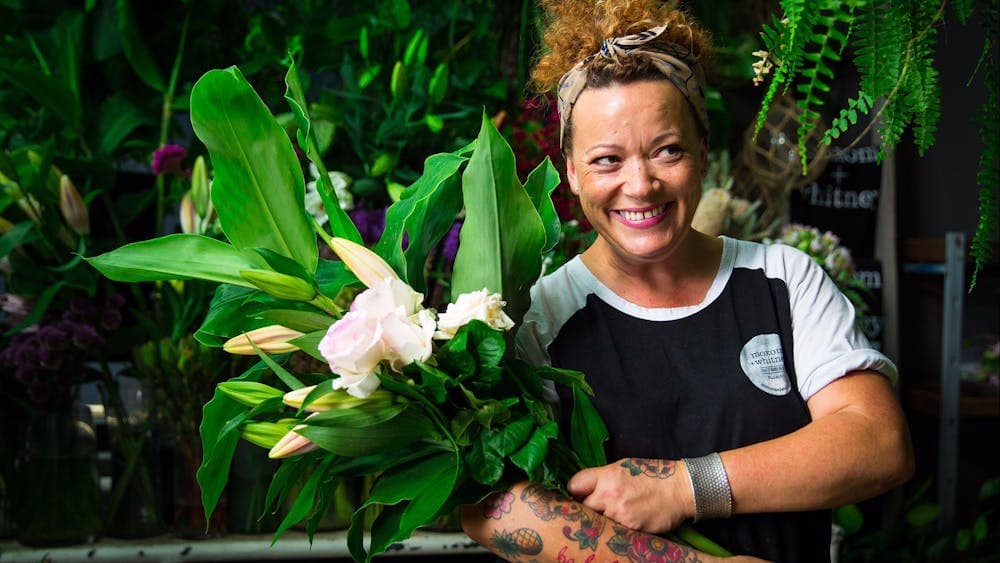 Florist with armful of beautiful blooms