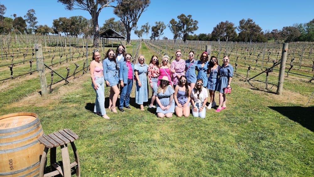 A diverse group of people standing together, smiling and posing for a photo.