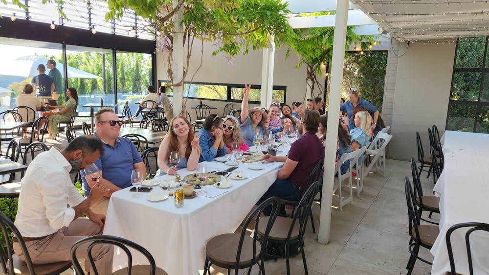 A group of individuals gathered around a table, engaged in conversation and enjoying a meal together