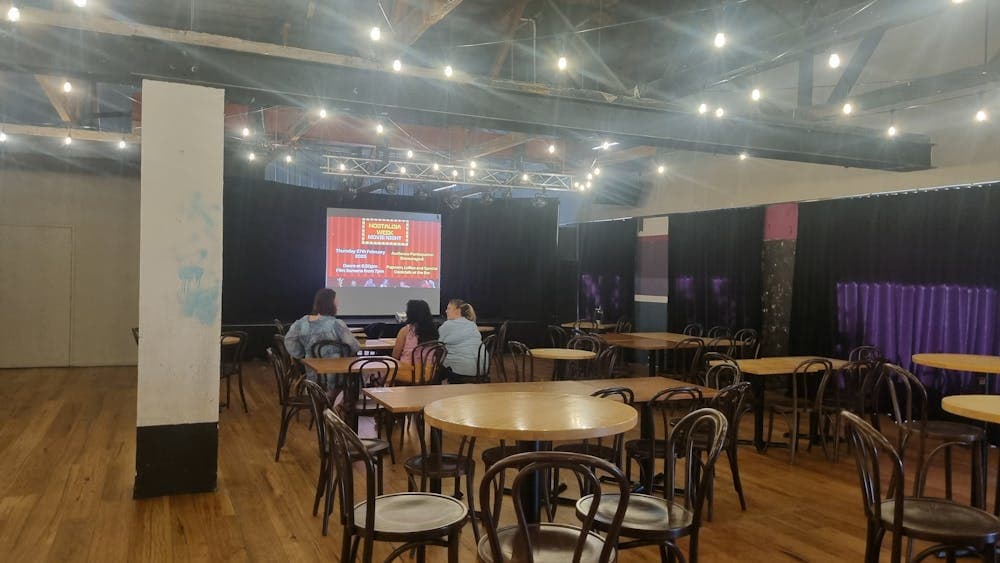 Tables and chairs with the screen up on the stage
