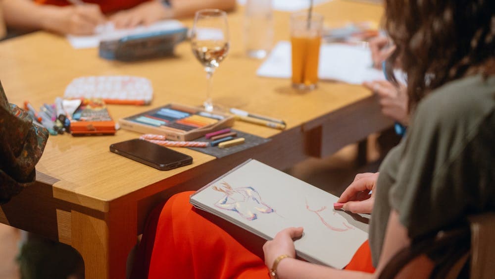 Person wearing colourful clothing drawing