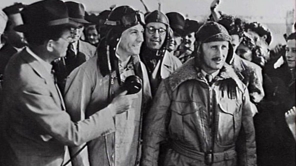 Black and white image of pilots surrounded by media