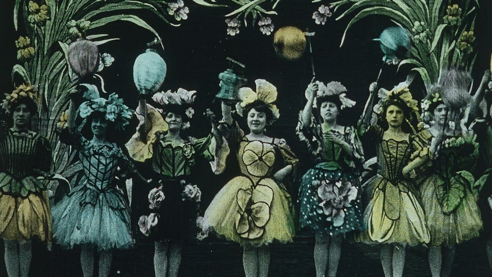 Vintage looking image of several women in a row dressed up in fancy dresses