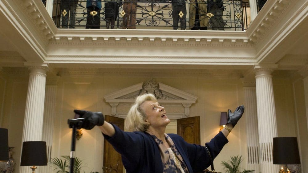 Woman stands happy looking up towards people on a balcony