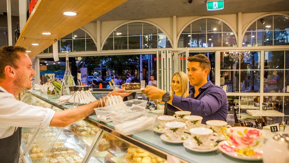 Couple couple being served cake over the counter