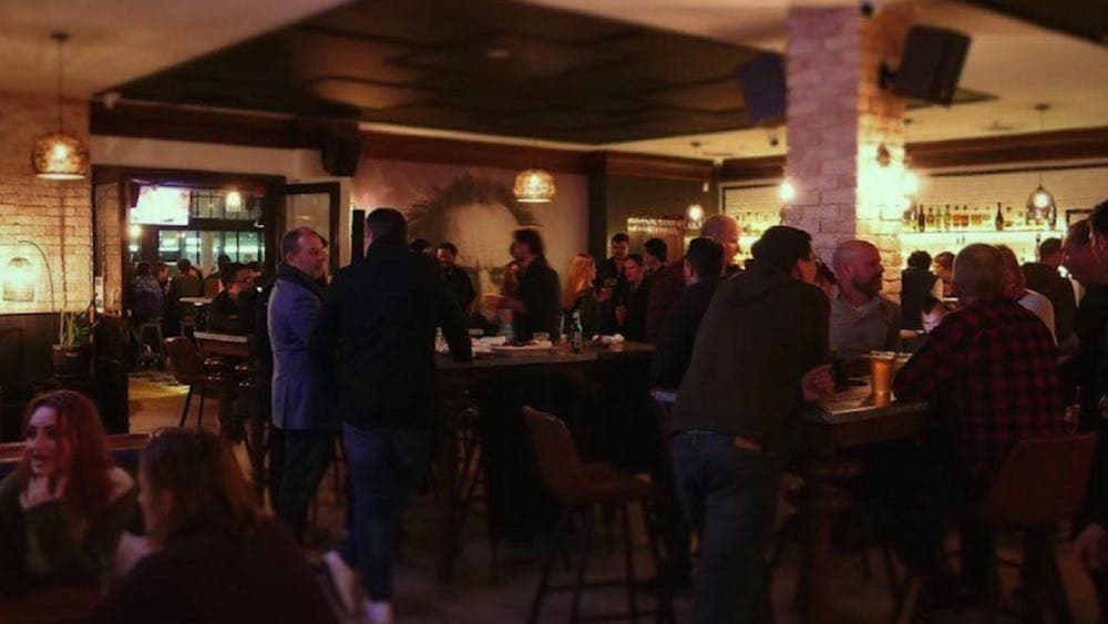 People standing at the bar talking