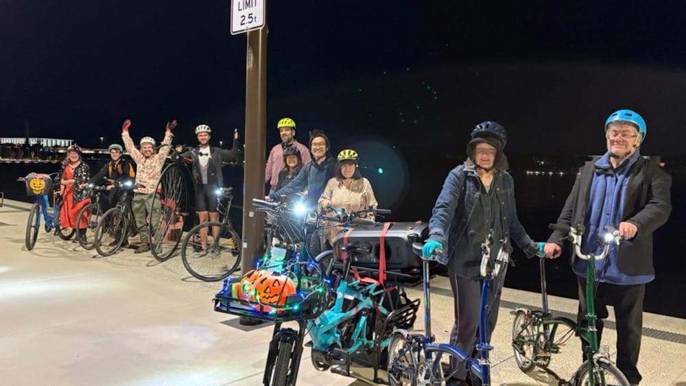 Bike party guests line up beside Lake Burley Griffin with their bikes.