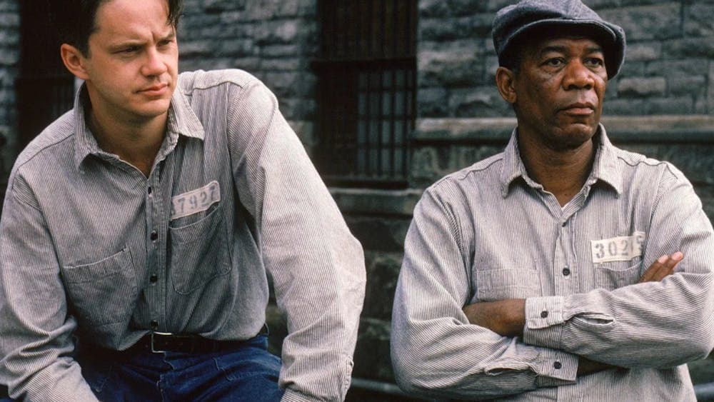 Two men dressed in prison shirts