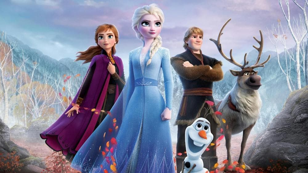 Two women, one male figure with a snowman and deer looking proud standing together
